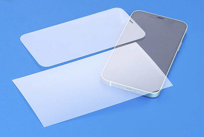 Lámina protectora para la pantalla y cristal templado de Hama sobre una mesa. También, con semitransparencia, hay un smartphone.