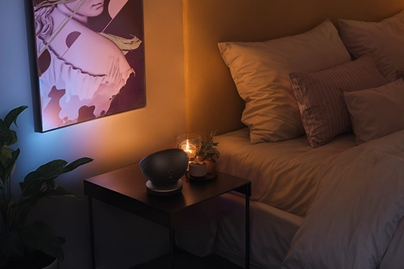 Lámparas y luz inteligentesLa lámpara de mesa LED inteligente de Hama se coloca sobre una mesa auxiliar en el dormitorio e ilumina indirectamente la pared de detrás de la cama con una agradable luz cálida.